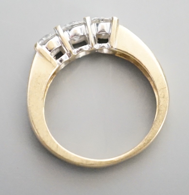 A 14k yellow metal and three stone diamond ring, with four stone diamond set shoulders, size K, gross weight 4.3 grams